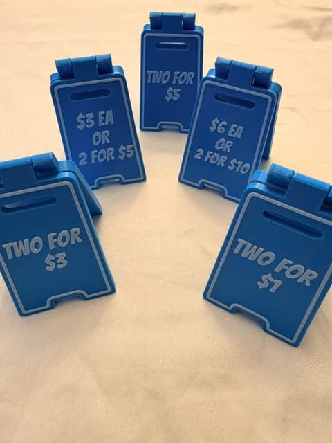 A set of printed price-card holders with sample prices like "Two for $5" and "$3 EA or 2 for $5"